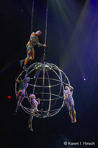 Flying sphere with man walking on top and 3 females hanging from interior